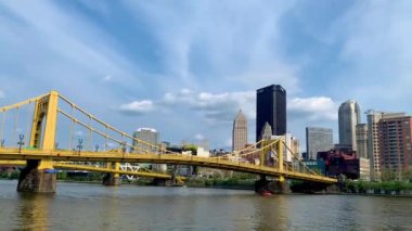 The cloudy blue sky over Andy Warhol Bridge seen from the Allegheny river waterfront with the Pittsburgh downtown in the background