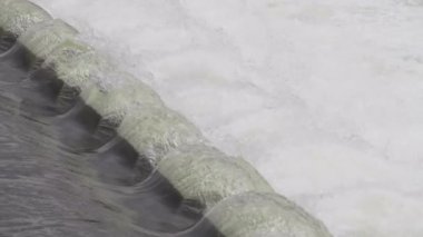 A closeup shot of a large artificial waterfall flowing and cascading with foam water