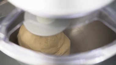 A closeup shot of a Flour dough and a kneading machine