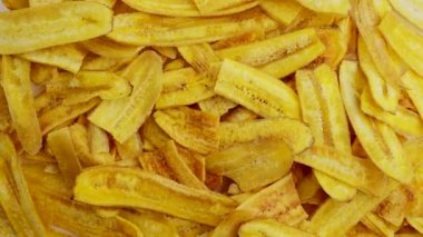 An overhead shot of a heap of banana chips rotating on a lazy Susan