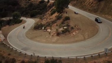 A beautiful view of a car and motorcycles on the road on a mountain