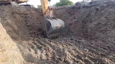 An Excavator at work. backhoe mechanical shovel working on the field, dig around or dig for a center pillar,