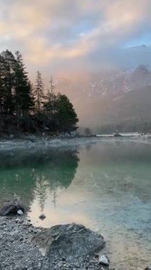 A vertical view of a lake with trees and mountains in the background