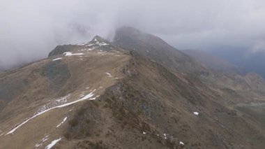 A beautiful view of a mountain range with foggy clouds
