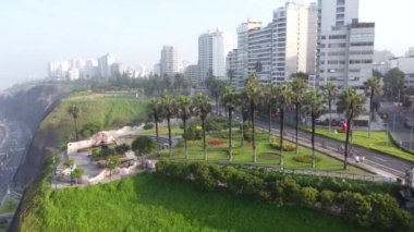 An aerial slow movement around cityscape Peru surrounded by tall white buildings