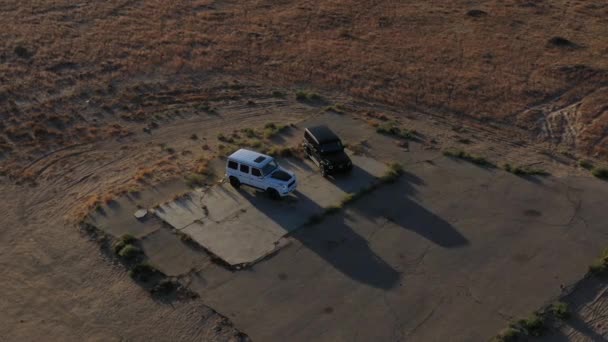 パルムデール砂漠で黒と白のメルセデス ベンツGクラスの車のドローンショット — ストック動画
