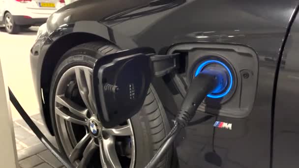 駐車場の電気Bmw車が充電されていることを意味するコンセント充電ドックを囲む点滅し 点滅するLedライト — ストック動画