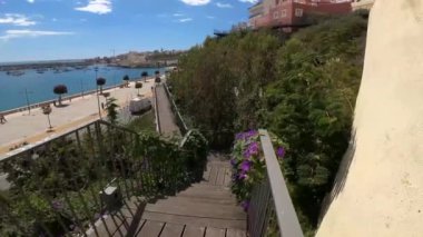 A beautiful motion walkway on stairs with a view of the beach on a sunny day.