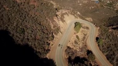 A beautiful view of a car and motorcycles on the road on a mountain