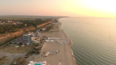 A bird's eye view of hotels on a sandy beach of the Black Sea reflecting sunrise in Zatoka, Ukraine