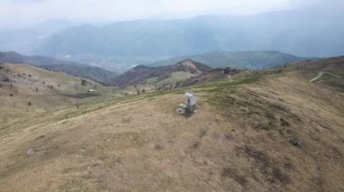 A Drone shot of a small christian sanctuary on top of a dry mountain