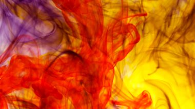 An abstract ink mix of yellow, purple and red in water on white background