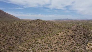 A beautiful drone view of mountains and roads under the blue cloudy sky