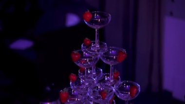 Kulüpteki loş mavi ışıklı piramit şeklindeki kokteyllerin yakın çekim görüntüsü..