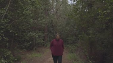 A Caucasian young female walking in a forest