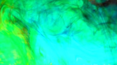 Abstract ink mix of blue and yellow in water creating a green hue