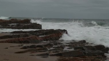 A closeup of stormy sea waves crashing into the rocky coast