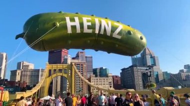 İnsanlar Pittsburgh, Pennsylvania 'daki Pickelsburgh turşu yemek festivalinin tadını çıkarıyor. Yaz boyunca havada dev Heinz Turşusu balonu vardı..
