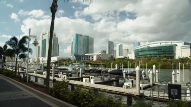 A beautiful shot of line of boats in a harbor with modern buildings in the background and cloudy sky over