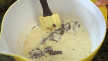 A slow motion of a chef mixing hot milk with the chocolate in a bowl