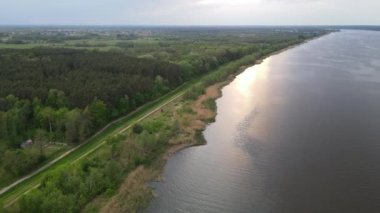 The sunshine reflected in the water of Lake of Zegrze with the forest on the left