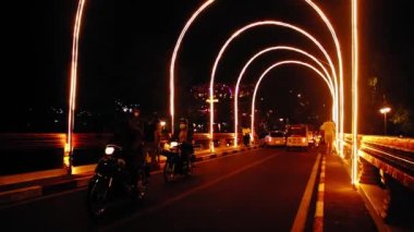 Motorist and people crossing the illuminated bridge in the Old Market of Siem Reap