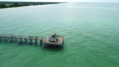 A high angle HD footage of a long bridge in the green sea at Naples beach in Fiori