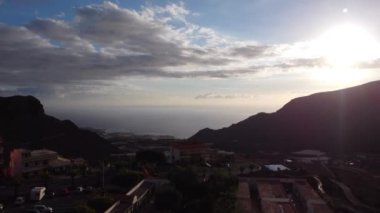 Aerial view of city Tamaimo, Tenerife, Canary Islands. La Gomera Island and Atlantic ocean in background just before sunset. Banana plantations aerial