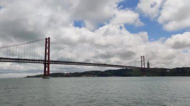 A Beautiful shot 25th of April Bridge under a blue cloudy sky  in Lisbon, Portugal
