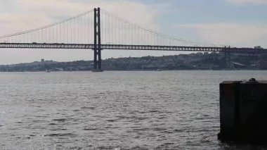 A scenic view of a bridge on the Tacho River flowing through Lisbon, Portugal on a sunny day
