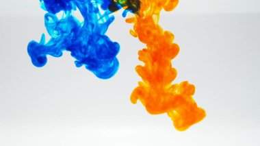 Abstract ink mix of blue and yellow in water on white background
