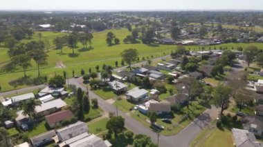 A bird's eye view of a residential district surrounded by greenery on a sunny day in Sydney, Australia