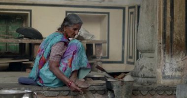 An Old woman cooking in her house in a village in India