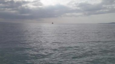 A small boat sailing on the beautiful sea on a cloudy day