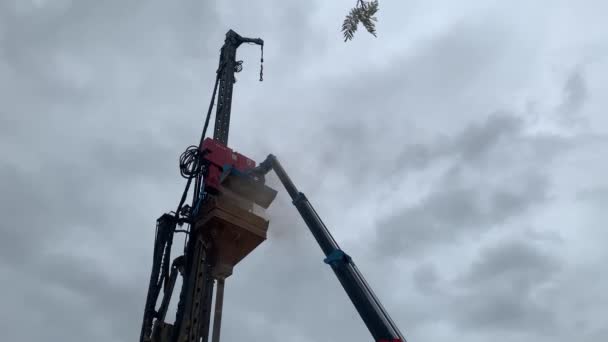 曇天下の建設現場で働くクレーンの眺め — ストック動画