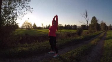 A woman doing stretching exercises on a trail
