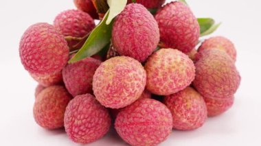 Beyaz arka planda dönen bir grup olgun lychee 'nin yakın çekimi.