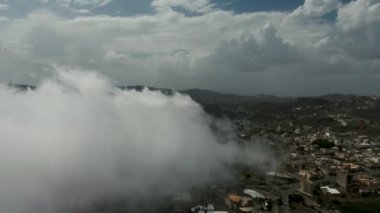 Kuzey Suudi Arabistan 'da, mavi bulutlu gökyüzünün altında güzel bir dağ ve şehrin büyüleyici drone görüntüsü.