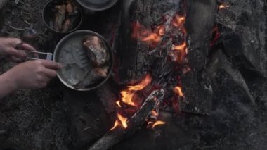 Kuzey Ontario Crownlands 'de kamp yaparken balık pişiren bir kişinin HD' si.