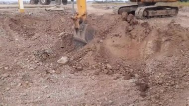 Hindistan 'daki inşaat alanında yük taşı ve toprak moorumunu traktöre dönüştüren bir kazıcı.