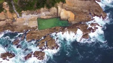 Bermagui, Avustralya 'da güzel bir deniz havuzu ve kaya manzarası.
