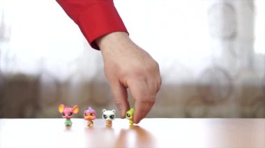 A close up Person with small toys arranging them on a table