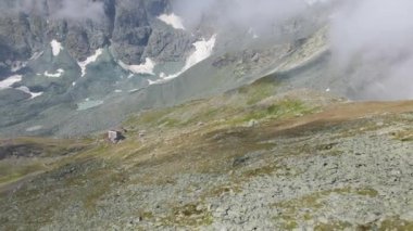 An aerial slow movement around greenery and rocky mountains