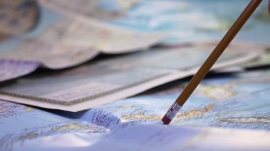 Dünya haritasını kalemle göstererek, seyahat planlaması için bir harita inceleyin