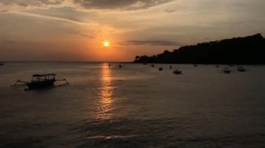 A time-lapse of a sea with calm waves under a cloudy sky during the sunset