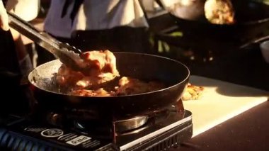 Khmer pan fried chicken being cooked on a portable gas stove