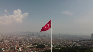 The aerial drone footage of the flag of Turkey on Camlica Hill against the Istanbul cityscape.