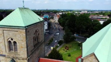Drone Shot of a Fly Through between Church Towers revealing Cars and a Tram