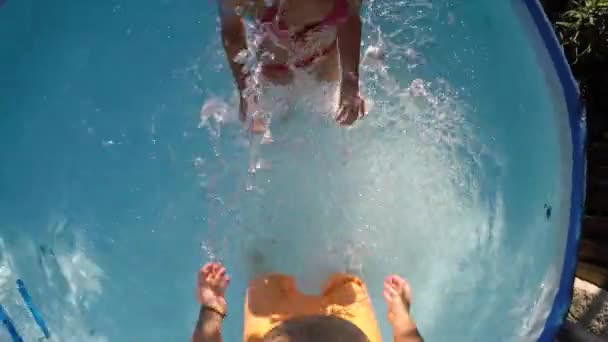 小さなインフレータブルプールで父と娘が水を撒く — ストック動画