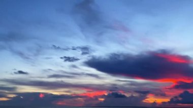 Renkli bulutlu bir arkaplanı olan sakin bir denizin güzel manzarası.